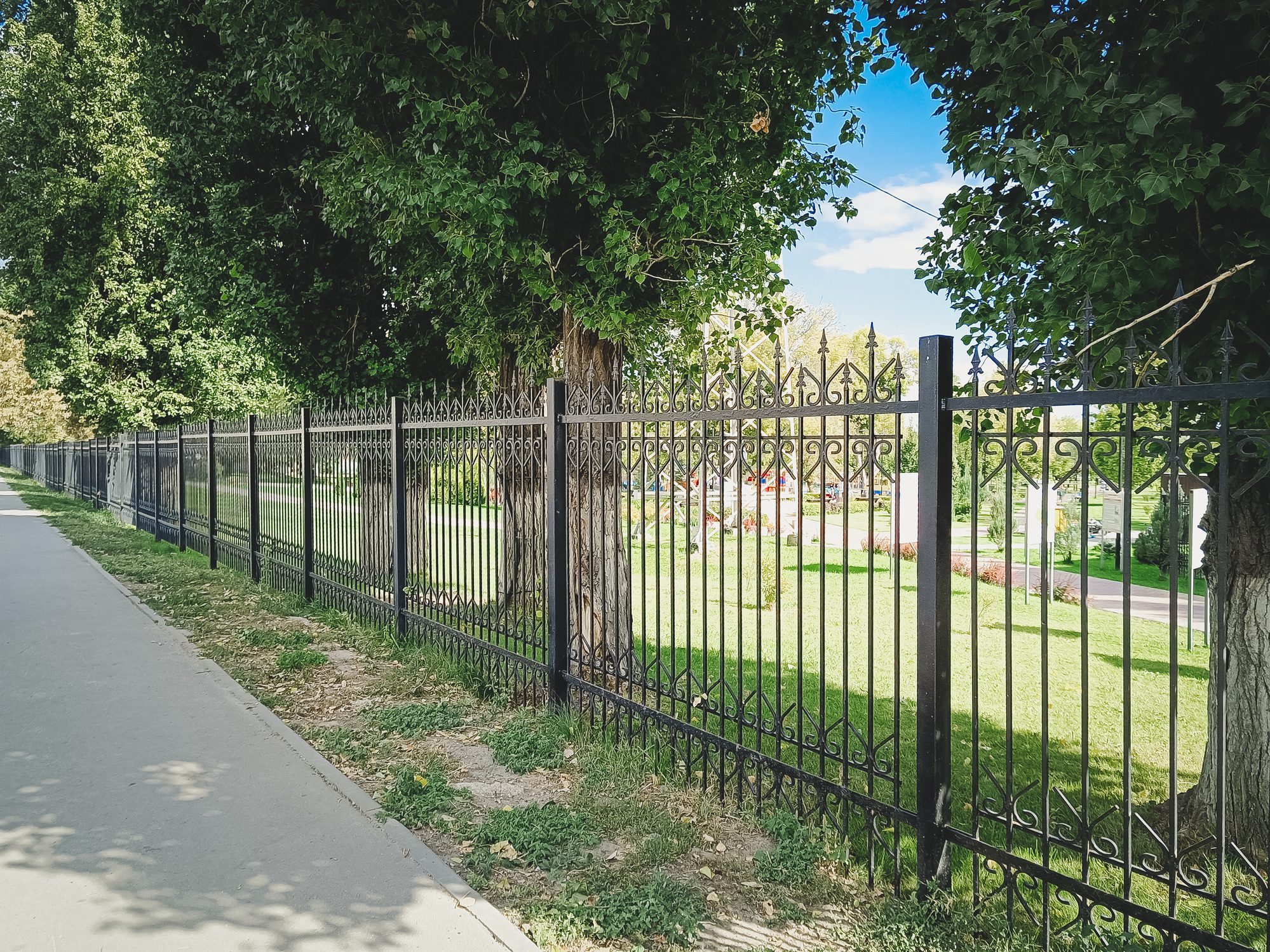 Black iron fence along a sidewalk